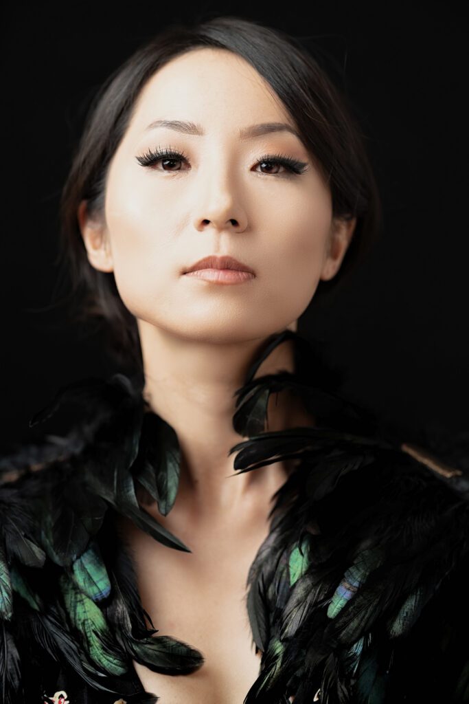 A woman with black feathers around her neck.