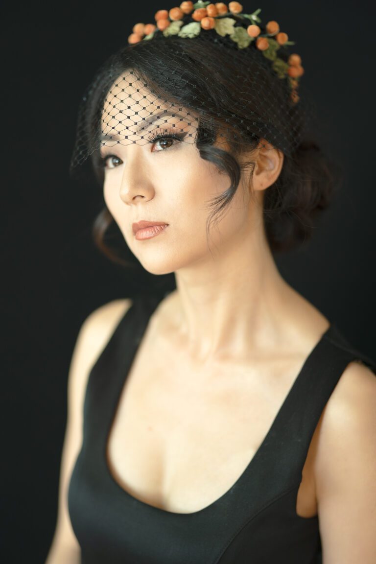 A woman with black hair wearing a veil.