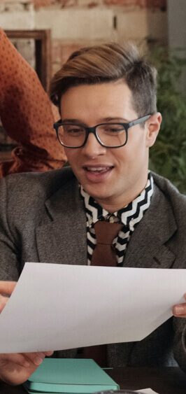 Person wearing glasses reading a document indoors.