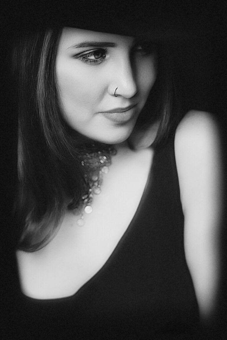Black and white close-up portrait of a woman in a sleeveless top.