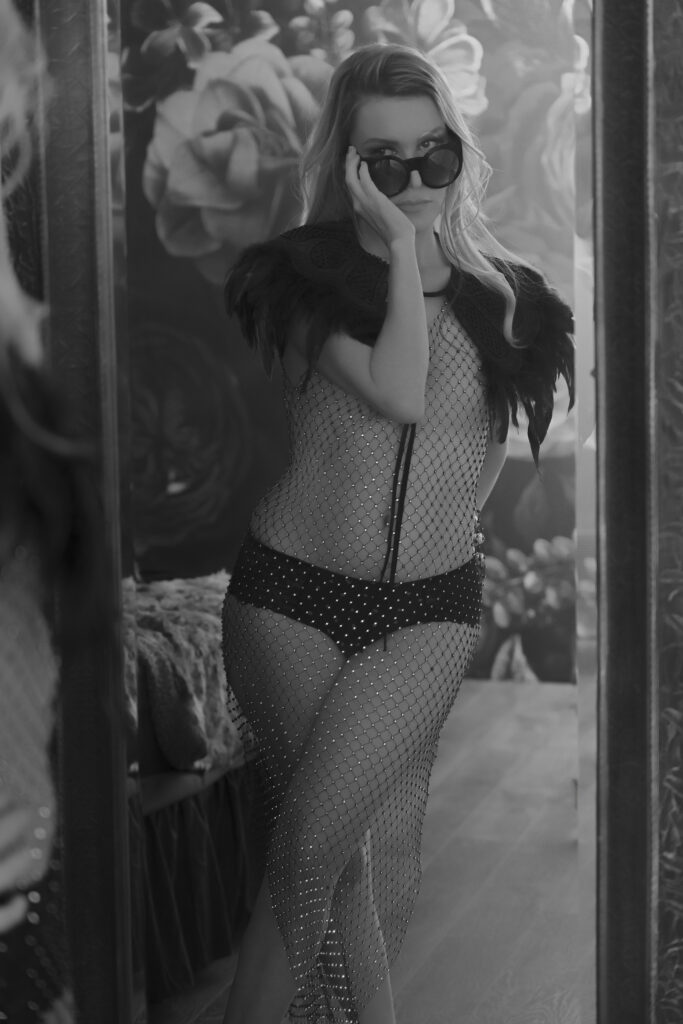Black and white boudoir photography session in Ann Arbor, Michigan — woman posing confidently in front of a mirror.